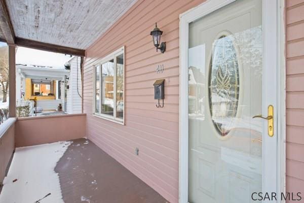 view of exterior entry featuring covered porch