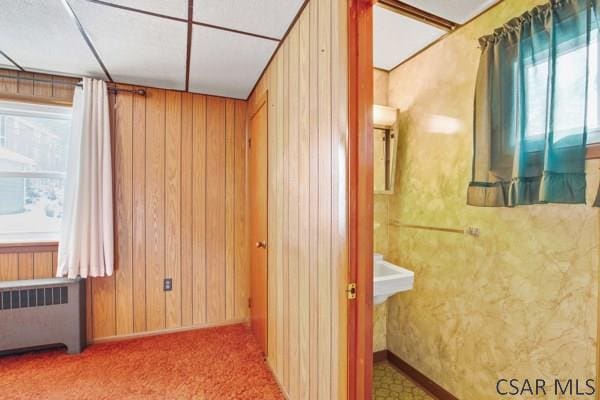 interior space featuring plenty of natural light, radiator heating unit, and wood walls