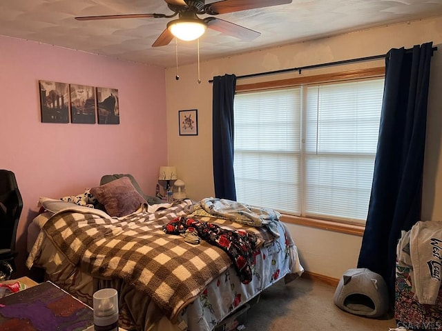 carpeted bedroom featuring a ceiling fan and baseboards