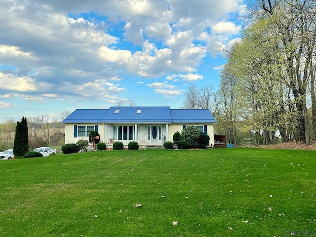 view of front of home with metal roof and a front yard