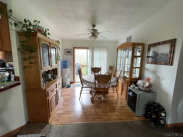dining space with baseboards, visible vents, ceiling fan, and light wood-style floors