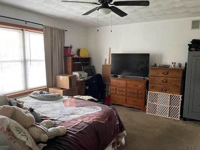 bedroom with carpet, visible vents, and a ceiling fan