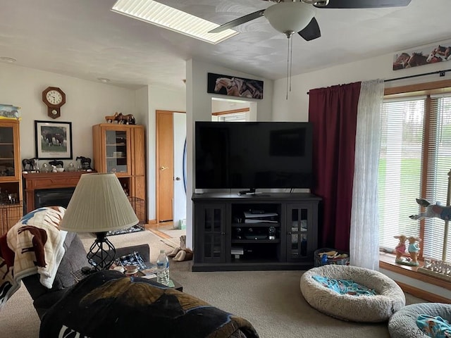 living room featuring ceiling fan, carpet floors, and a fireplace