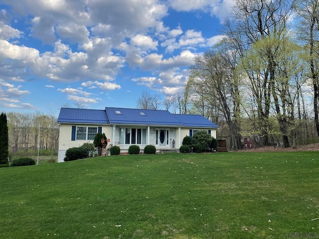 view of front of house featuring metal roof and a front lawn