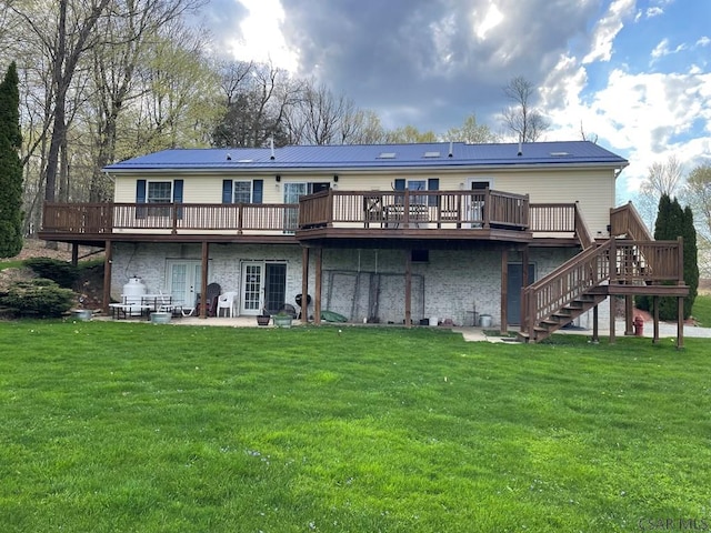 back of property with a deck, a yard, stairs, and a patio