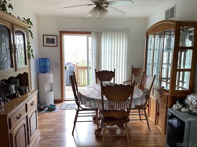 dining space featuring visible vents, a ceiling fan, and light wood finished floors