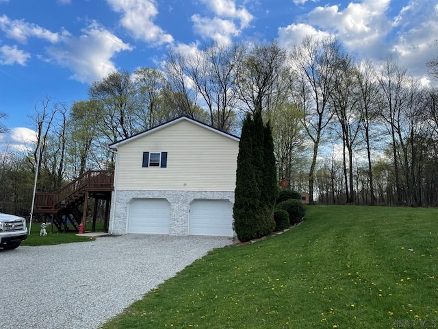 view of side of property featuring driveway, a yard, stairway, and an attached garage