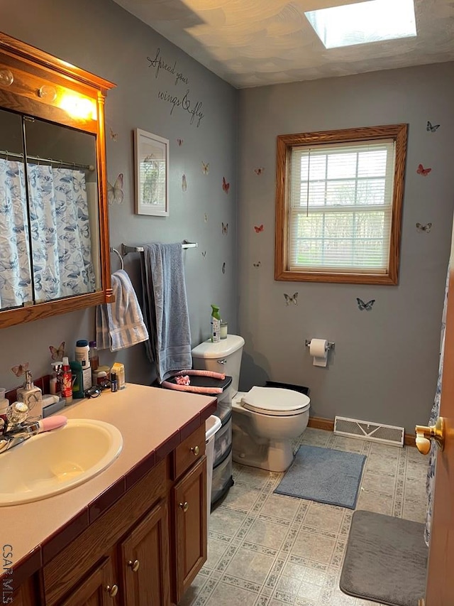 full bathroom featuring toilet, curtained shower, vanity, baseboards, and visible vents