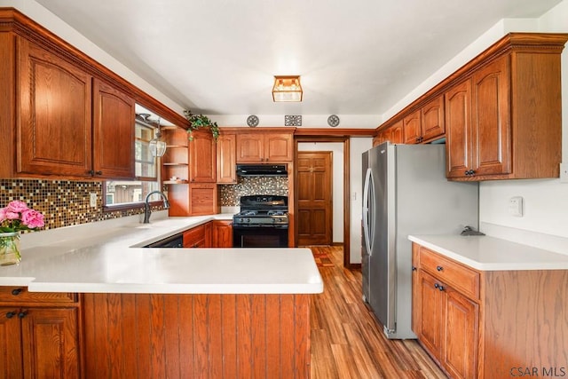 258 Samuels Rd, Somerset, PA 15501 - kitchen with gas stove, light countertops, light wood-style floors, backsplash, and a peninsula