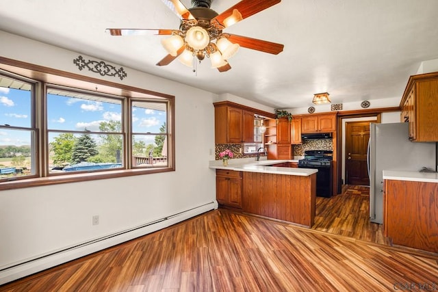 258 Samuels Rd, Somerset, PA 15501 - kitchen featuring gas stove, a baseboard heating unit, a peninsula, under cabinet range hood, and light countertops