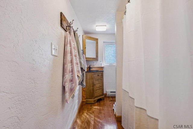 1139 Chickentown Rd, Somerset, PA 15501 - corridor featuring a baseboard radiator, a textured wall, dark wood-type flooring, and a sink