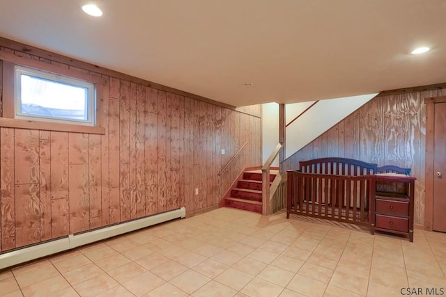 basement with stairway, wooden walls, recessed lighting, and baseboard heating