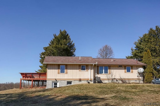 back of house featuring a wooden deck and a lawn