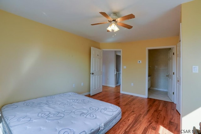 bedroom featuring ceiling fan, baseboards, and wood finished floors