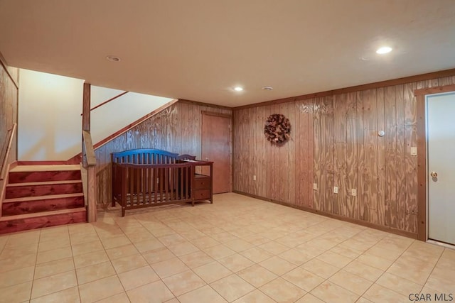 interior space featuring stairs, recessed lighting, baseboards, and wood walls