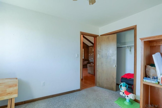 carpeted bedroom featuring baseboards and a closet