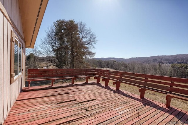 wooden deck with a wooded view