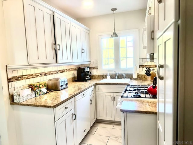 kitchen with sink, white appliances, white cabinetry, tasteful backsplash, and decorative light fixtures