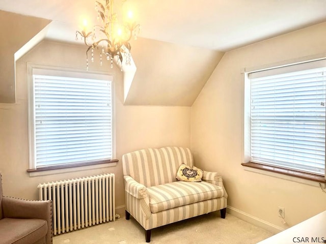 living area with lofted ceiling, radiator, a chandelier, and carpet