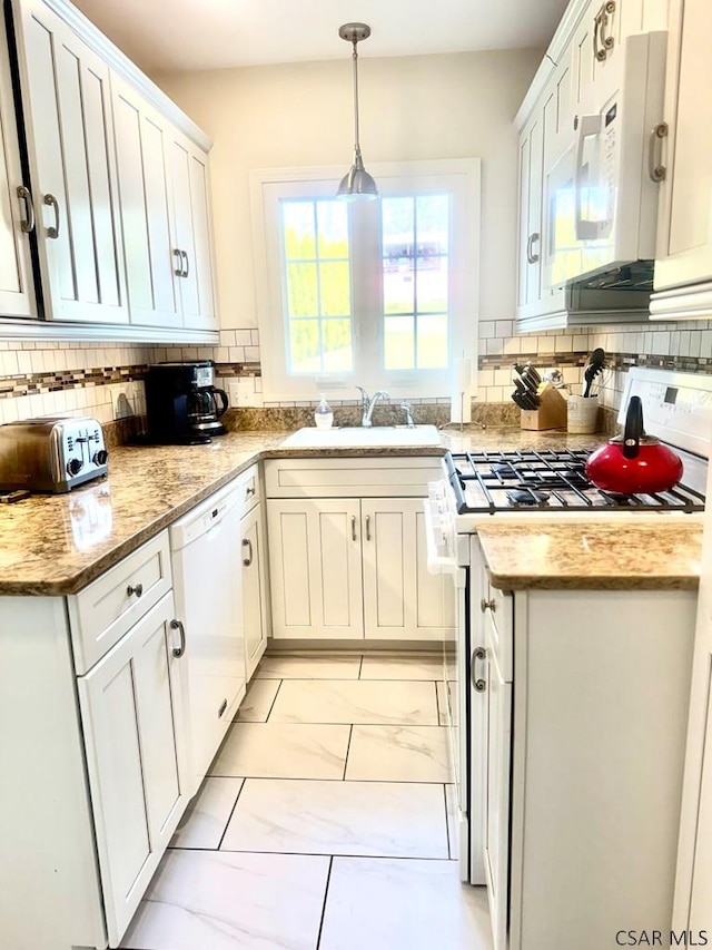 kitchen featuring sink, white cabinetry, tasteful backsplash, decorative light fixtures, and white appliances