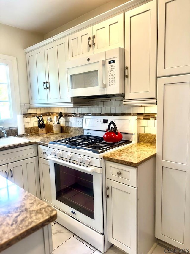 kitchen featuring white cabinetry, sink, backsplash, and white appliances