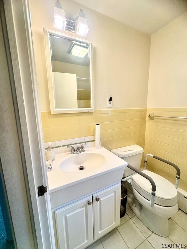 bathroom with vanity, toilet, tile patterned flooring, and tile walls