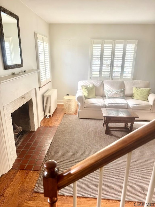 living room featuring a tile fireplace, radiator, and dark hardwood / wood-style flooring