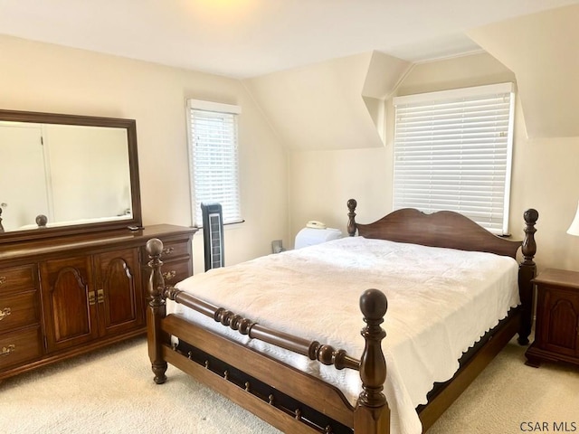 bedroom featuring light colored carpet and vaulted ceiling