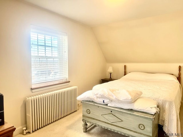 carpeted bedroom with radiator and vaulted ceiling