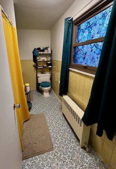 520 Highland Ave, Connellsville, PA 15425 - bathroom featuring radiator heating unit, tile walls, and toilet
