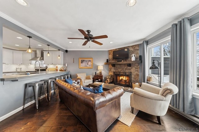 living room with dark wood-type flooring, a fireplace, recessed lighting, and crown molding