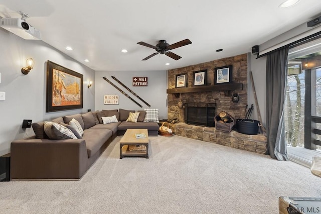 living area with recessed lighting, carpet, a ceiling fan, and a stone fireplace