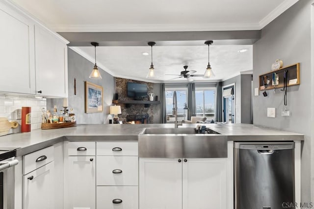 kitchen with ornamental molding, a sink, a peninsula, and stainless steel dishwasher