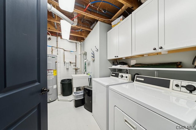 laundry area featuring washing machine and dryer, a sink, water heater, cabinet space, and concrete block wall