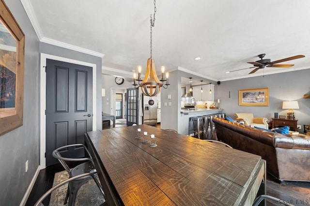 dining room featuring baseboards, dark wood-type flooring, crown molding, and ceiling fan with notable chandelier