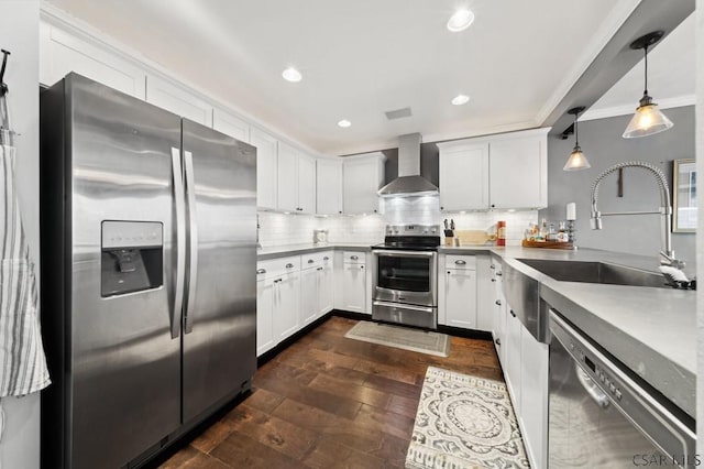 kitchen featuring decorative backsplash, wall chimney exhaust hood, dark wood-type flooring, stainless steel appliances, and a sink