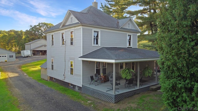 back of house featuring a garage and an outdoor structure