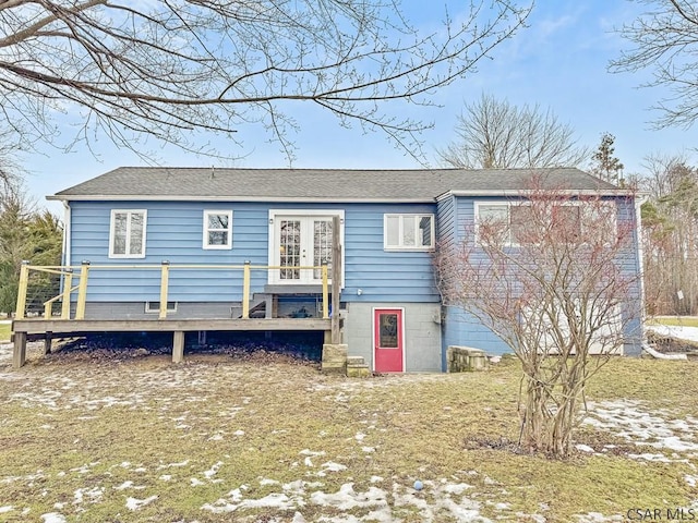 rear view of property with a deck and roof with shingles