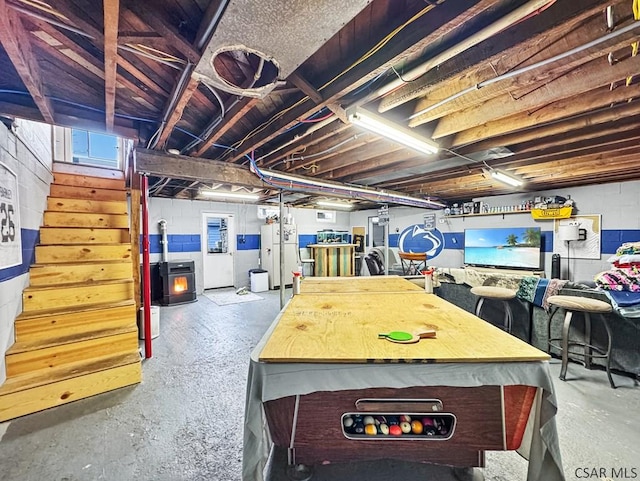 basement featuring freestanding refrigerator and stairs