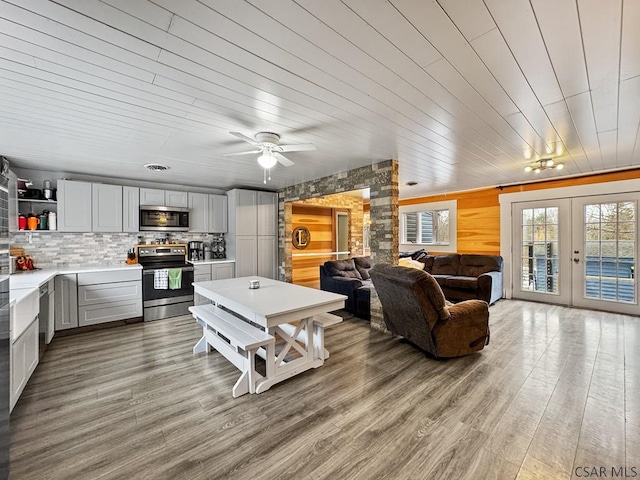 living room featuring french doors, light wood-type flooring, and wood ceiling