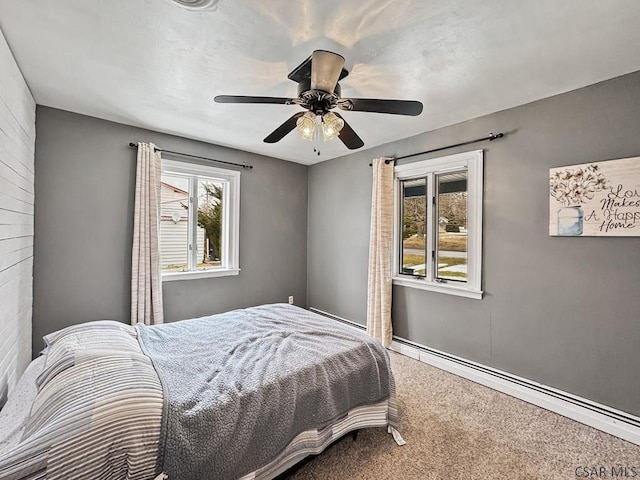 bedroom with carpet, baseboard heating, and a ceiling fan