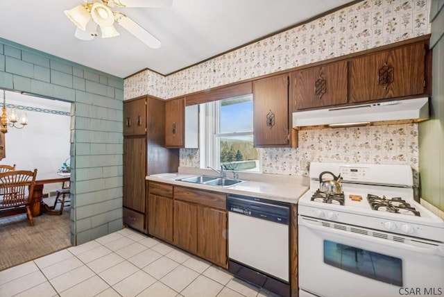 kitchen with ceiling fan with notable chandelier, sink, light tile patterned floors, and white appliances