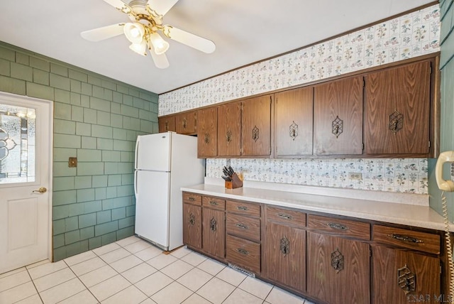 kitchen featuring light tile patterned flooring, white fridge, and ceiling fan