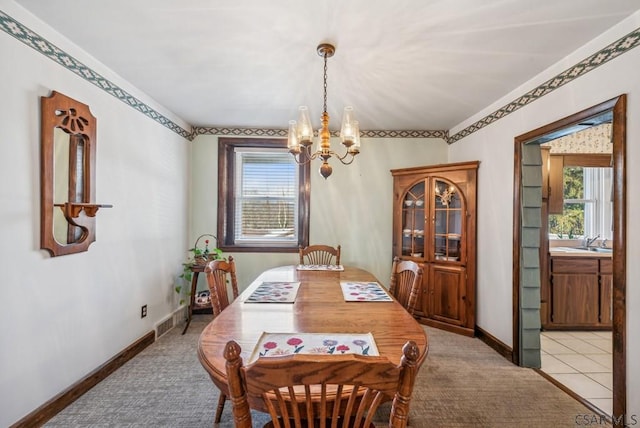 tiled dining area featuring an inviting chandelier, sink, and plenty of natural light