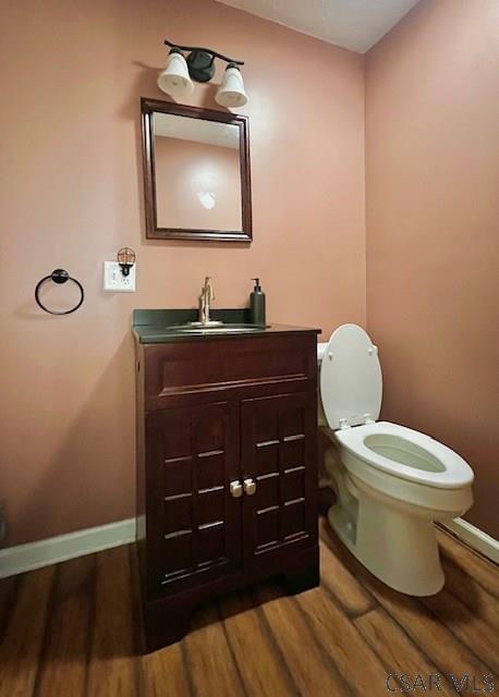 bathroom with hardwood / wood-style flooring, vanity, and toilet