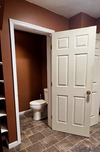 bathroom with a textured ceiling and toilet