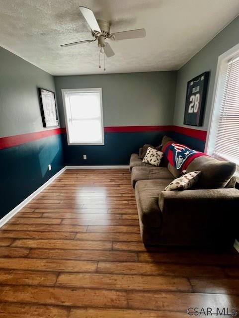 living room with a healthy amount of sunlight, hardwood / wood-style floors, a textured ceiling, and ceiling fan