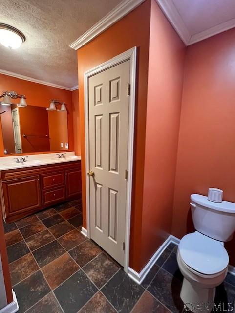 bathroom with vanity, crown molding, toilet, and a textured ceiling