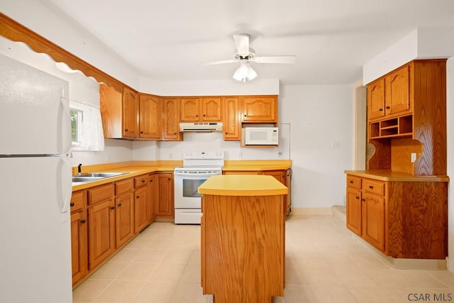 kitchen with white appliances, under cabinet range hood, a kitchen island, a sink, and a ceiling fan