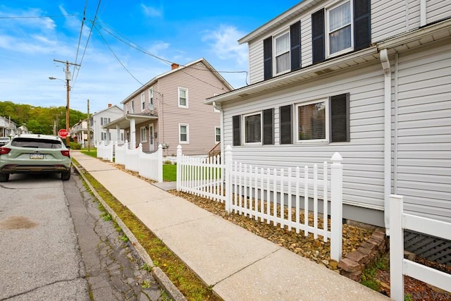 view of property exterior featuring fence and a residential view
